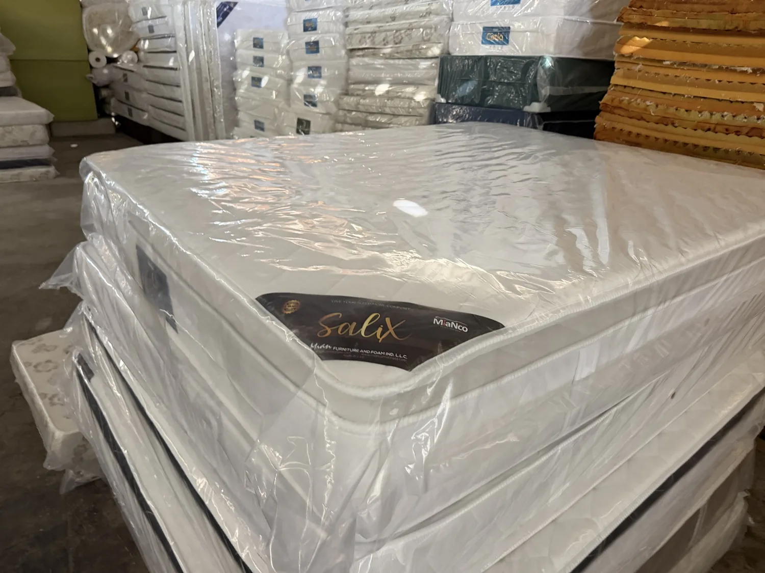 Real wrapped mattress inventory photographed at supplier warehouse